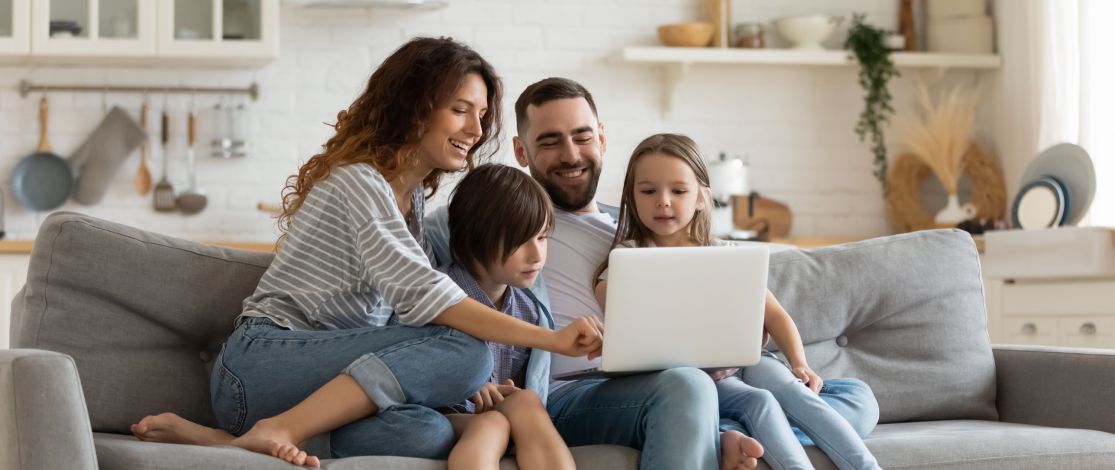 Family on a new Couch looking at a laptop together