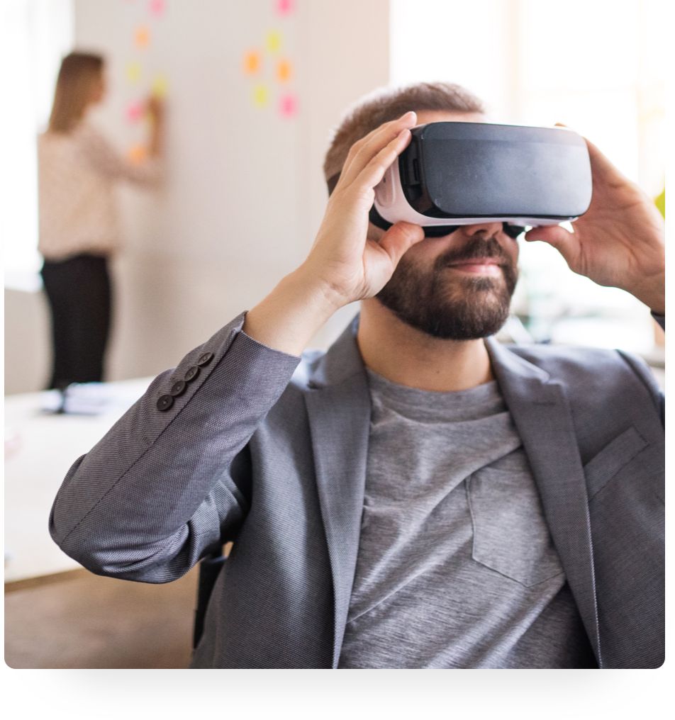  A man is holding a virtual reality headset up to his eyes. 