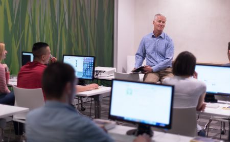 College students sitting in a computer lab listening to their professor