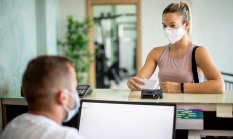 Woman paying for a gym membership at the desk